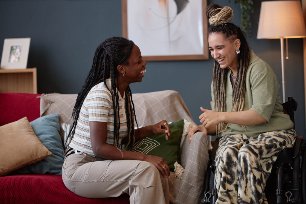 Young Black Woman and Young Caucasian Woman with Disability Laughing Together